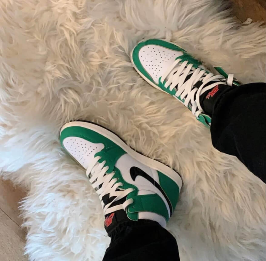 green and white sneakers showcased on white fur rug